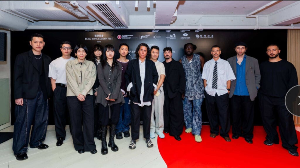 Sara Sozzani Maino posing with emerging Italian and Hong Kong menswear designers at the Future Threads exhibition.
